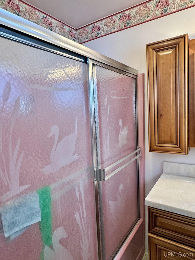 full bath featuring combined bath / shower with glass door and vanity