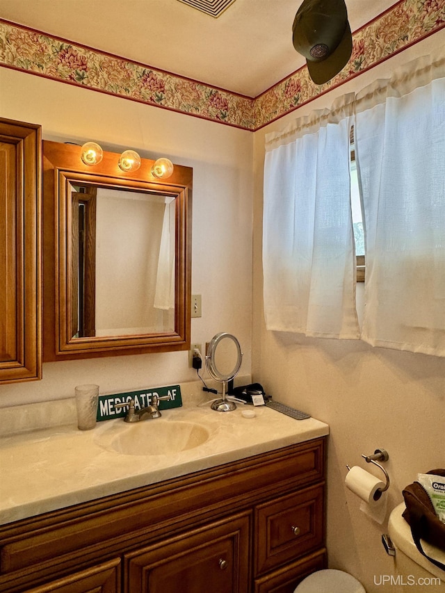 bathroom featuring toilet, visible vents, and vanity