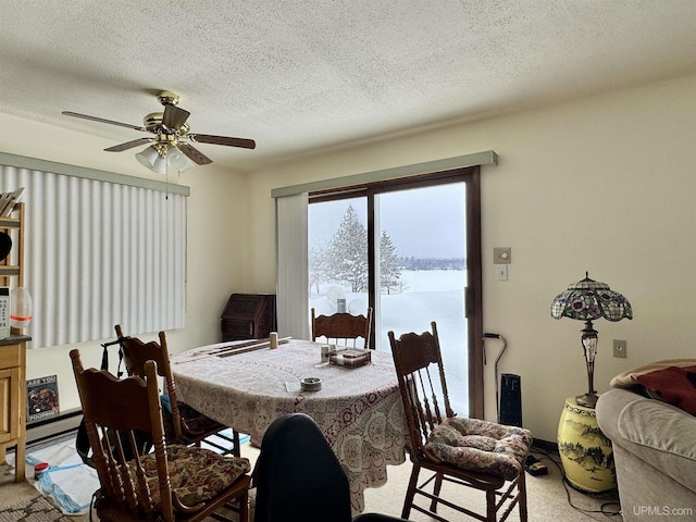 dining area with a ceiling fan, a textured ceiling, and light colored carpet