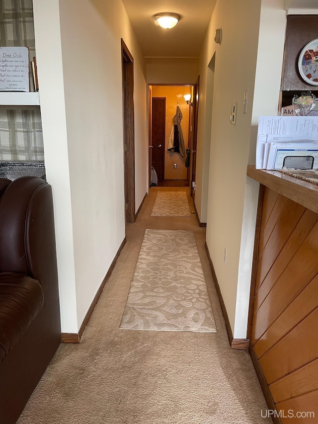 corridor with carpet floors and baseboards