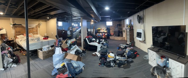 basement featuring dark colored carpet and heating unit