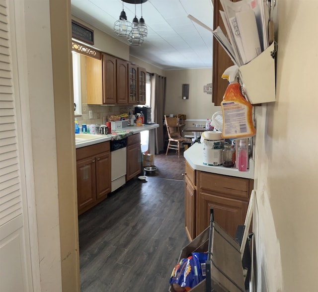 kitchen with pendant lighting, dark hardwood / wood-style floors, dishwashing machine, and decorative backsplash