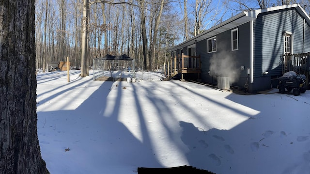 snowy yard featuring central AC unit