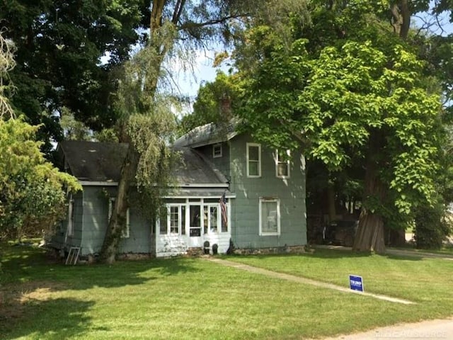 rear view of property featuring a lawn