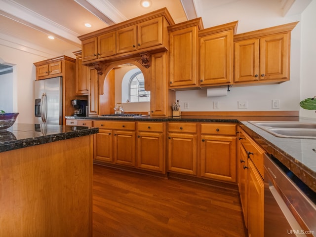 kitchen featuring brown cabinetry, crown molding, stainless steel appliances, and dark wood-style flooring