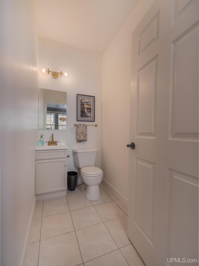 half bath with baseboards, vanity, toilet, and tile patterned floors