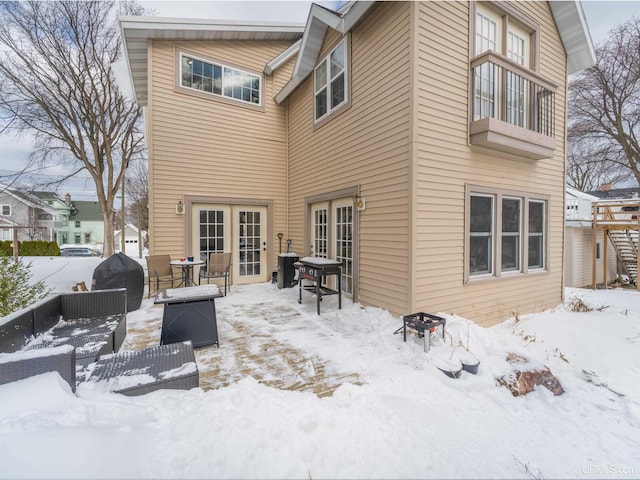 snow covered house featuring french doors