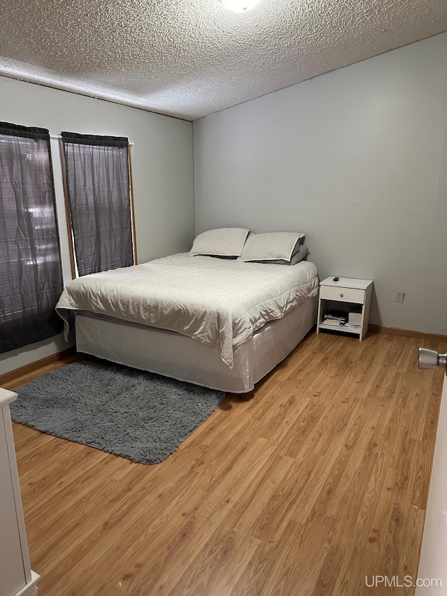 bedroom featuring a textured ceiling and light hardwood / wood-style floors