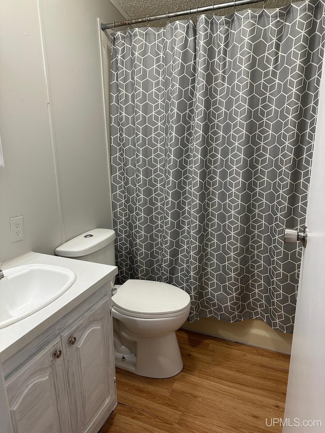 bathroom with hardwood / wood-style flooring, vanity, toilet, and a shower with shower curtain