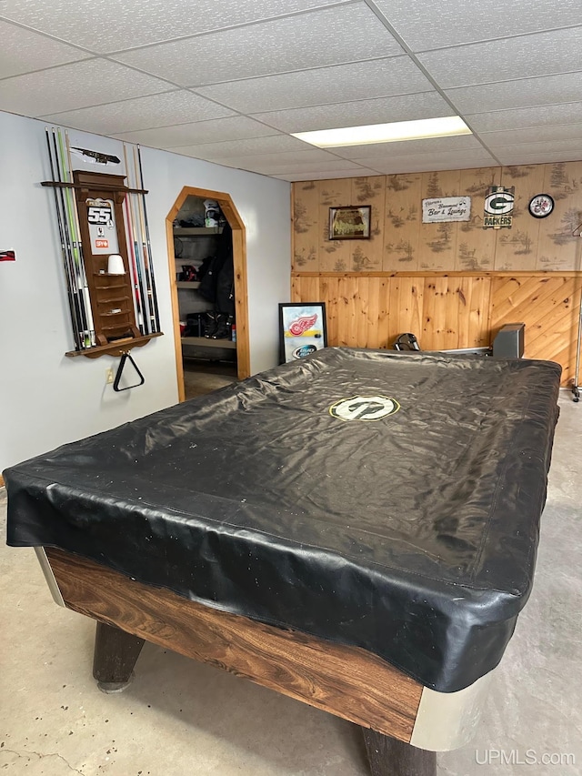 rec room featuring billiards, wooden walls, concrete flooring, and a paneled ceiling