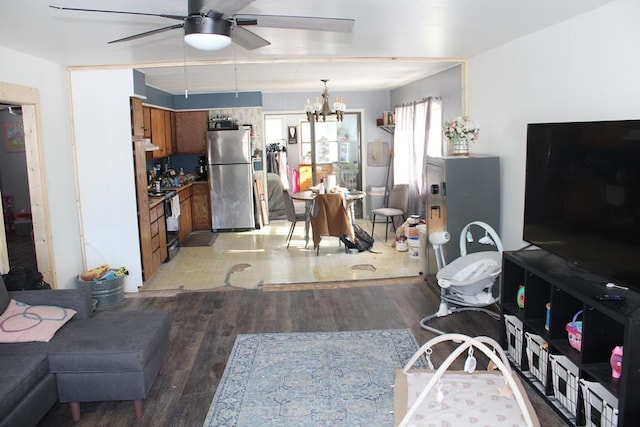 living room with ceiling fan with notable chandelier and light wood-type flooring