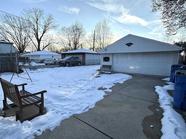 yard covered in snow with an outbuilding and a garage