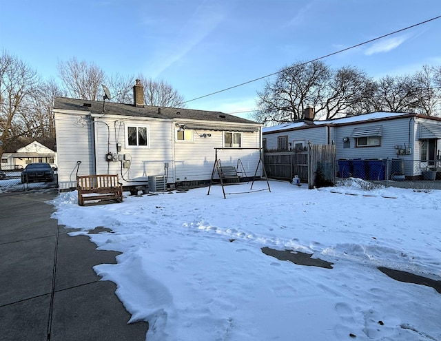 snow covered house featuring cooling unit