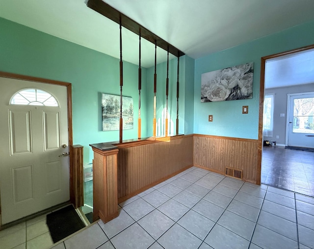 tiled entrance foyer featuring wooden walls