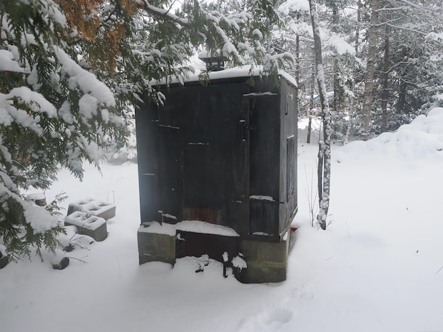 snow covered structure featuring a garage