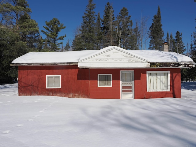 view of snowy exterior with concrete block siding