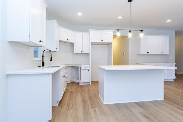 kitchen with pendant lighting, sink, and white cabinets