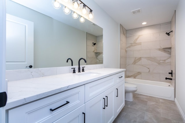 full bathroom with vanity, tiled shower / bath, and toilet