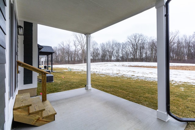 snow covered patio with a yard and central AC unit