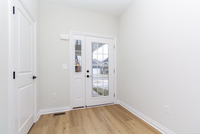 doorway featuring a wealth of natural light and light hardwood / wood-style flooring