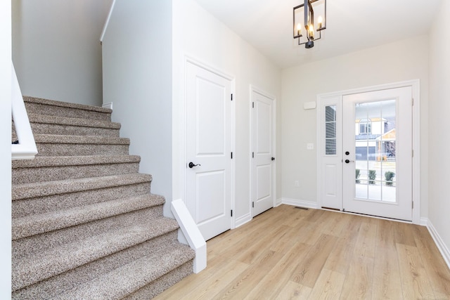 foyer with an inviting chandelier and light wood-type flooring