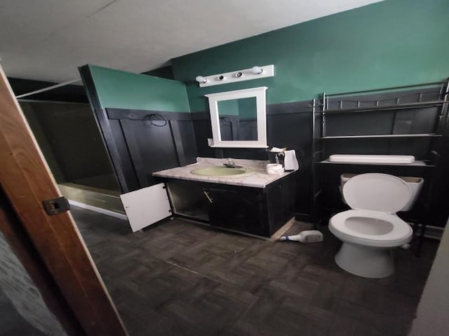 bathroom with vanity, toilet, parquet floors, and walk in shower