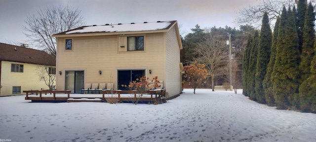 view of snow covered rear of property