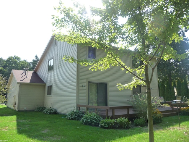 rear view of house featuring a deck and a lawn