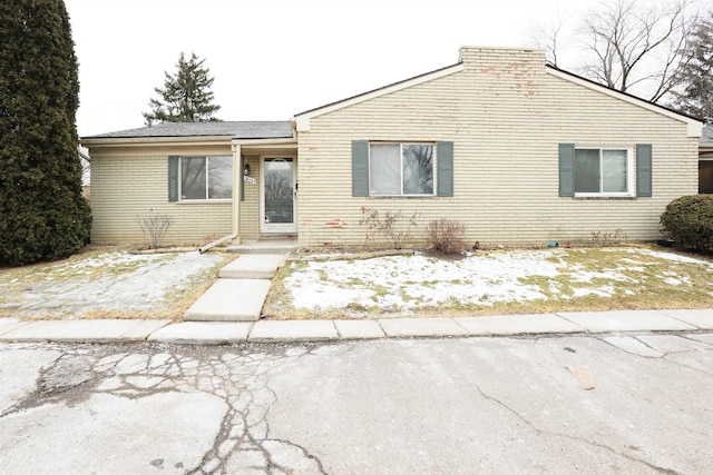 single story home featuring brick siding