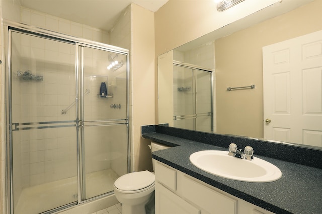 bathroom with vanity, a shower with shower door, and toilet