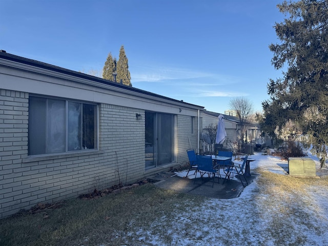 exterior space featuring a patio area and brick siding