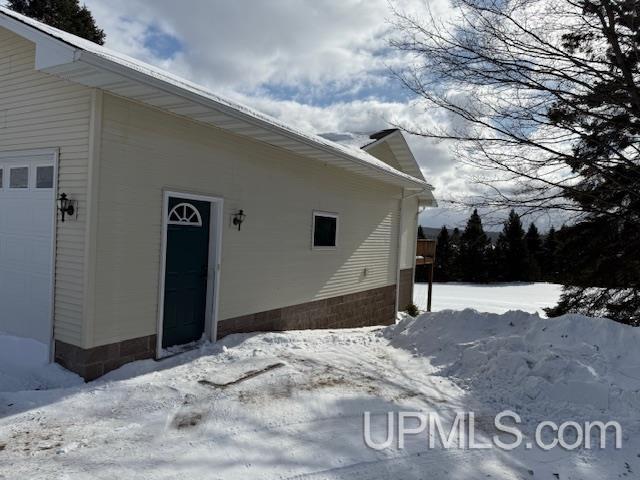 snow covered property featuring a garage