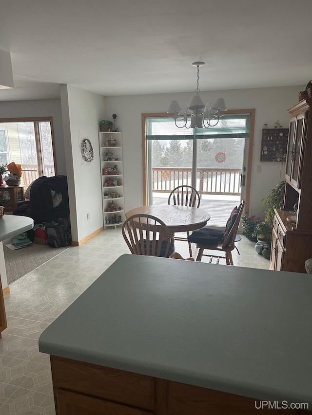 dining area featuring baseboards, a wealth of natural light, and a notable chandelier