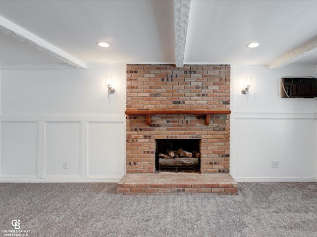 unfurnished living room with a fireplace, beamed ceiling, and carpet flooring