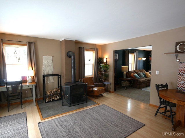 living room with a wood stove and light hardwood / wood-style flooring