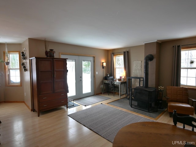 entryway with french doors, a wood stove, and light hardwood / wood-style flooring