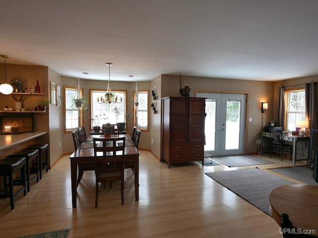 dining area featuring french doors, plenty of natural light, and light hardwood / wood-style flooring