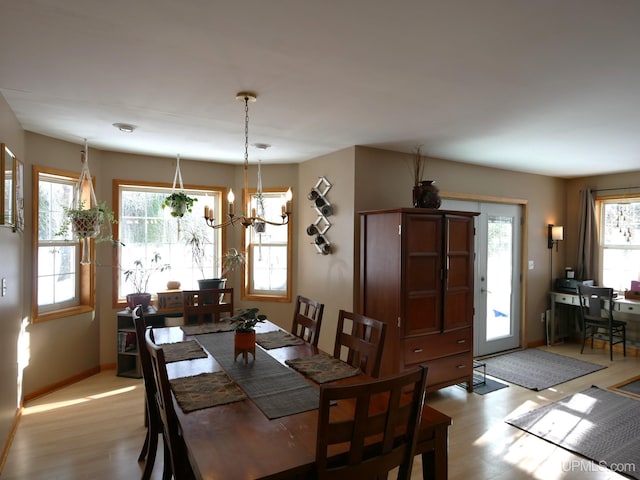 dining room with an inviting chandelier, light hardwood / wood-style floors, and a healthy amount of sunlight