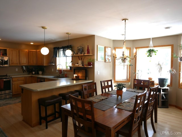 dining area with a chandelier, light hardwood / wood-style floors, and sink