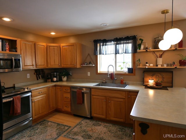 kitchen featuring appliances with stainless steel finishes, sink, and decorative light fixtures