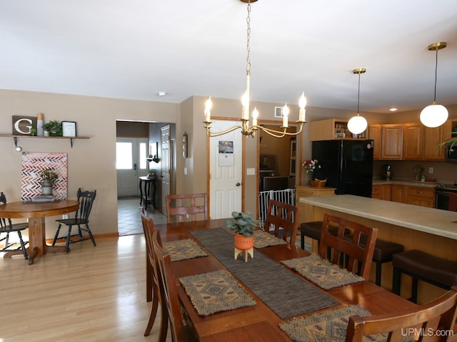 dining space with an inviting chandelier and light hardwood / wood-style floors