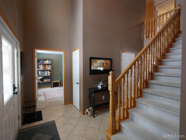 tiled foyer entrance featuring a high ceiling and a healthy amount of sunlight