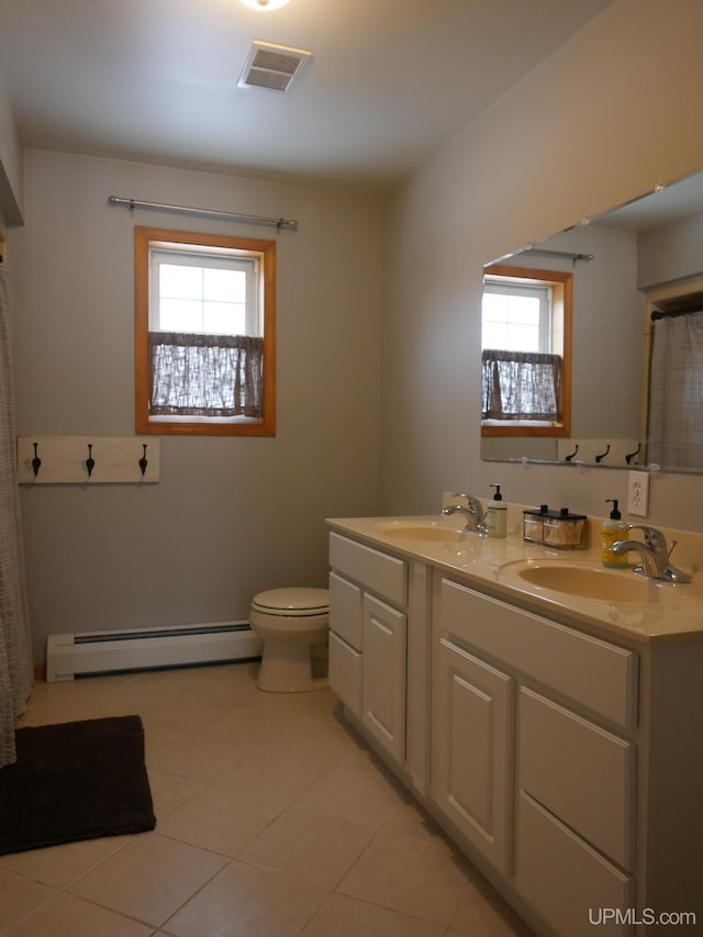 bathroom featuring baseboard heating, plenty of natural light, toilet, and vanity