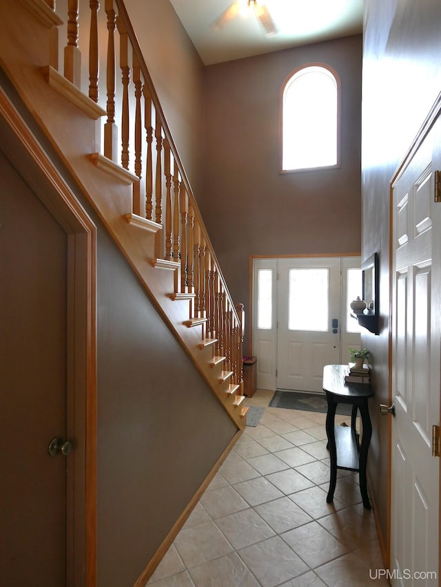 entrance foyer with a high ceiling, light tile patterned flooring, and a wealth of natural light