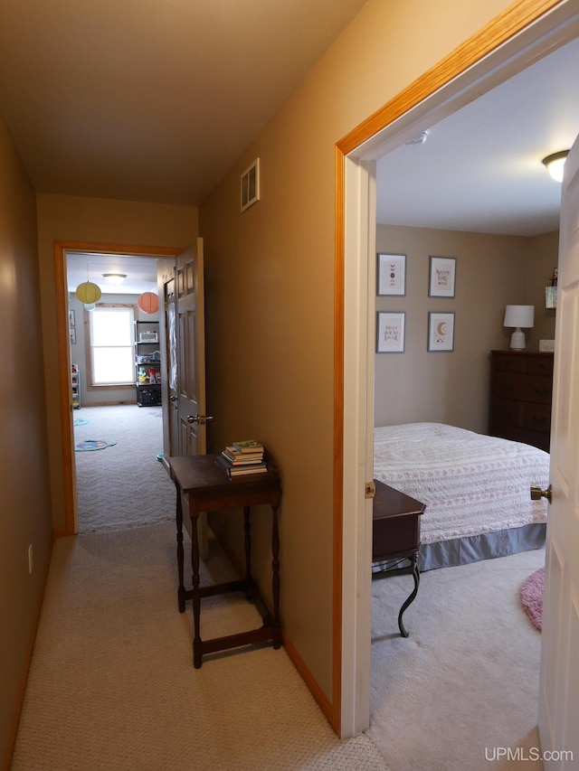 corridor featuring light colored carpet