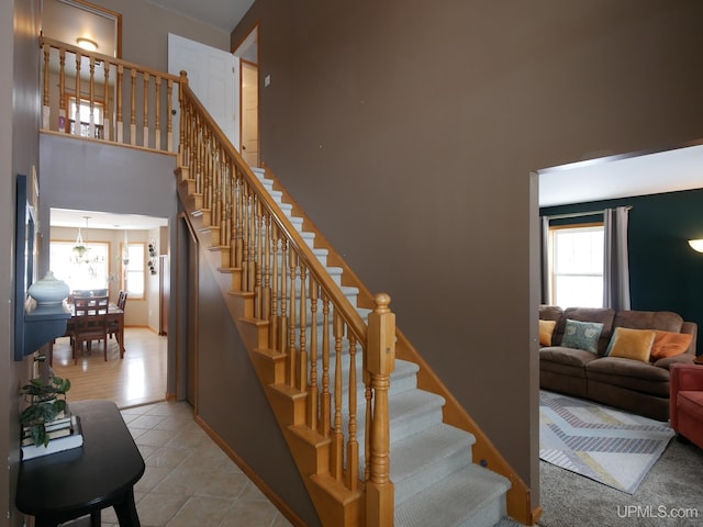 stairway with a high ceiling and tile patterned floors