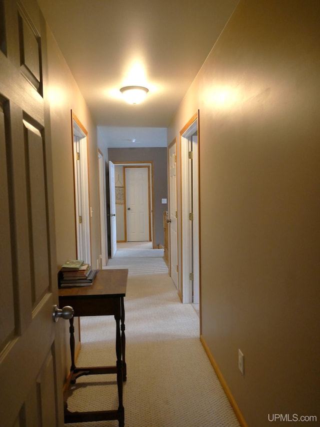 hallway featuring light colored carpet