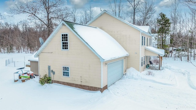 view of snow covered exterior with a garage