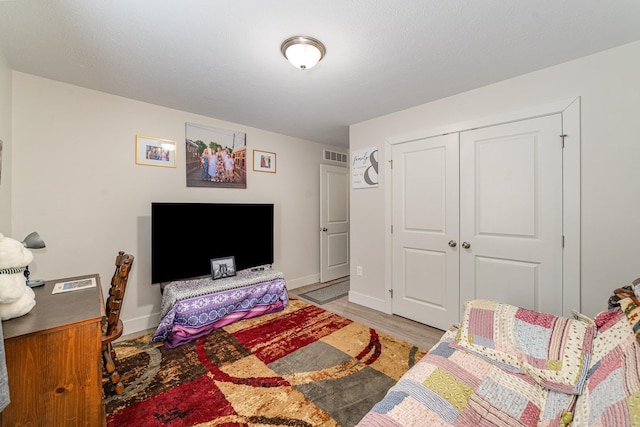 bedroom featuring wood-type flooring and a closet