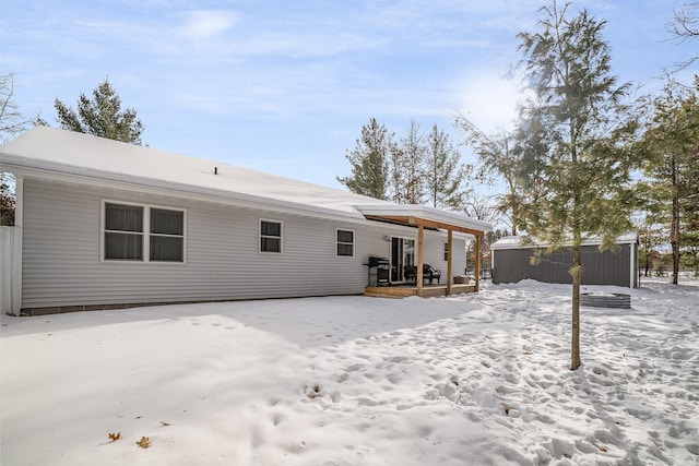 snow covered rear of property featuring covered porch